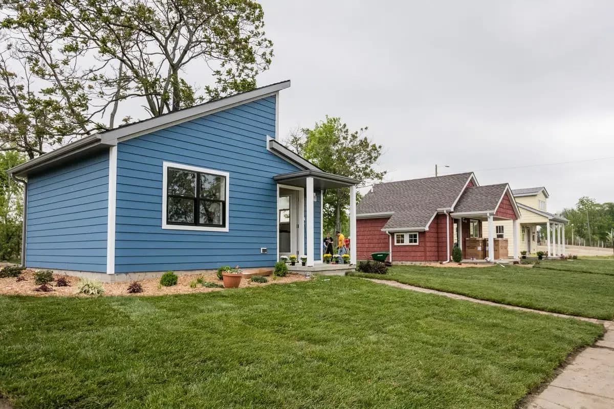 A blue tiny home with angled roof and white trim.