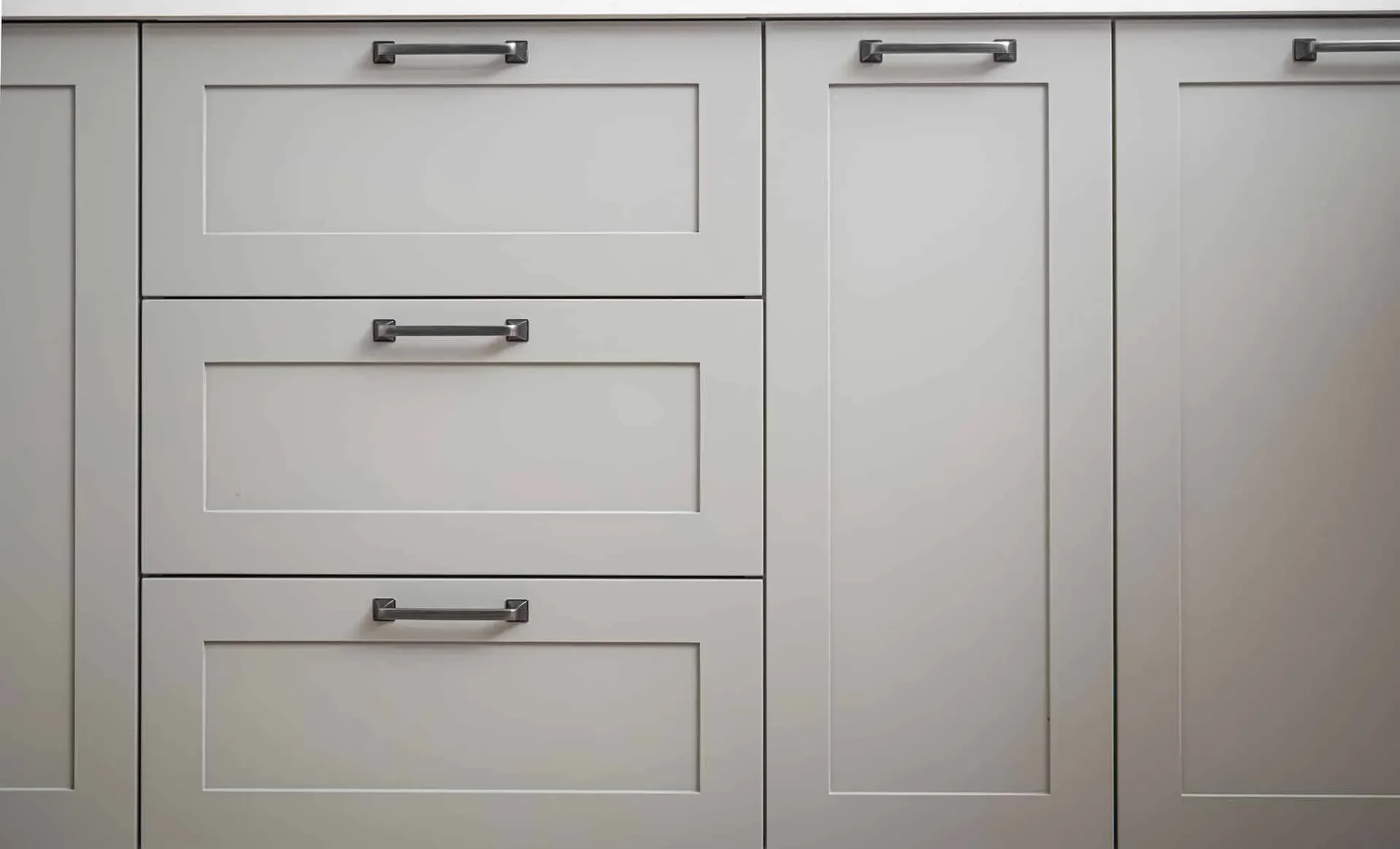 White Kraftmaid cabinets with brushed steel handles.