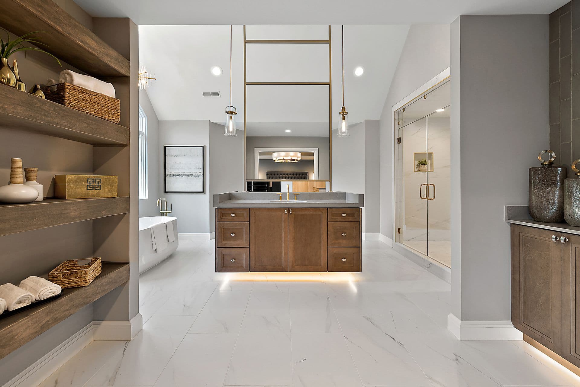Modern luxury bathroom with double vanity, marble flooring, wood cabinetry, pendant lighting, freestanding tub, walk-in shower, and floating wood shelves with decorative accessories
