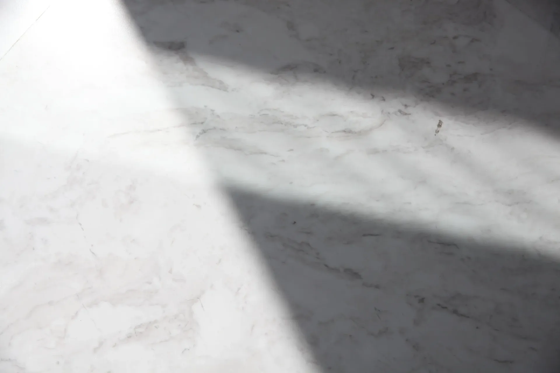 Shadows fall on white marbled countertop.