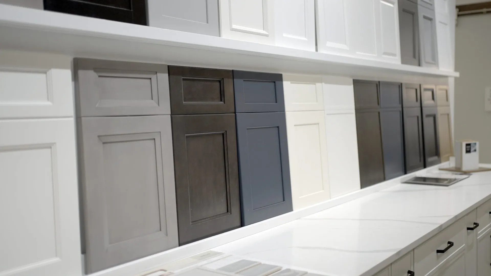 A row of different colored cabinet faces in a showroom.